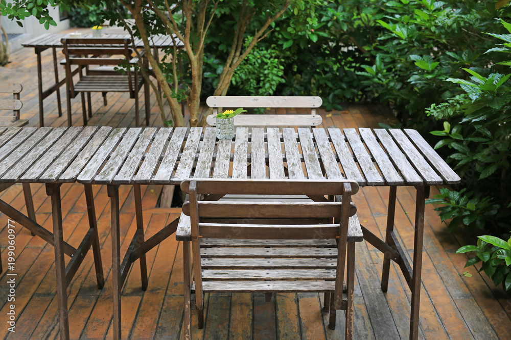 wooden table and chair in the garden with glass of flower decoration. wooden table and chair in the garden with glass of flower decoration.