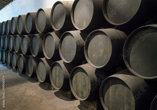 Row of stacked wooden wine barrels for sherry aging