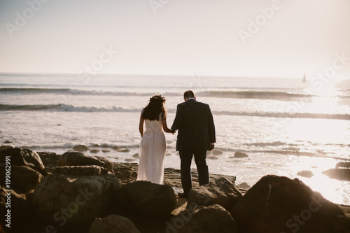 bride and groom looking out at the ocean on their wedding day
