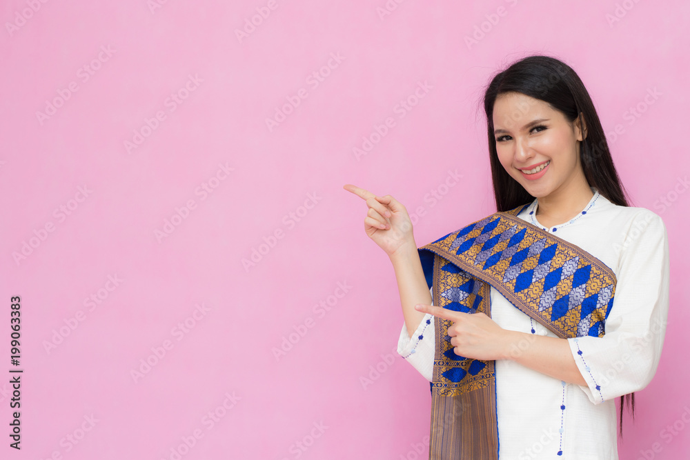 Portrait beautiful Asian girl in traditional Thai dress isolated on pink background. .Cotton Dress Portrait beautiful Asian girl in traditional Thai dress isolated on pink background. .Cotton Dress