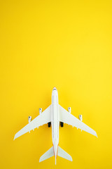 Flat lay design of travel concept with plane  on yellow background with copy space.