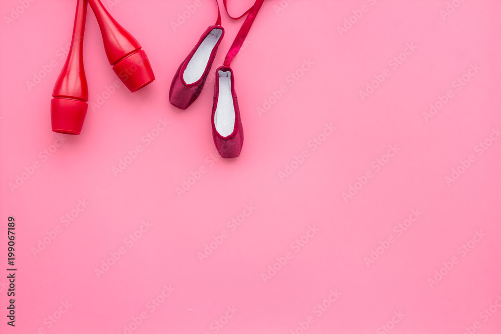 Beauty sport for girls concept. Maces for rhythmic gymnastics and ballet shoes on pink background top view copy space