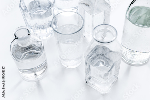 Drinks on the table. Pure water in jar and glasses on white background