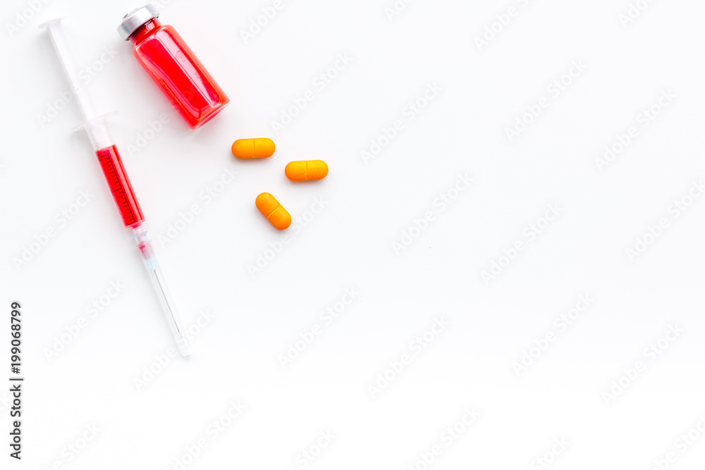 Medical therapy. Syringe, bottle with drug, pills on white background top view copy space Medical therapy. Syringe, bottle with drug, pills on white background top view copy space