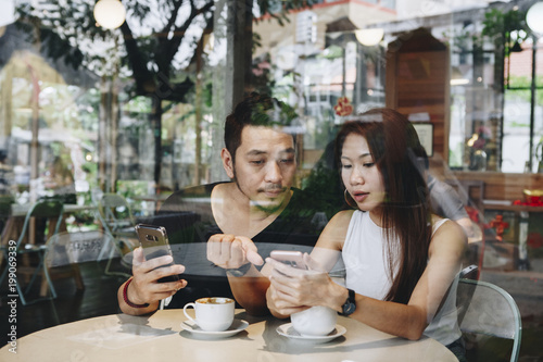 Couple using a phone at a cafe