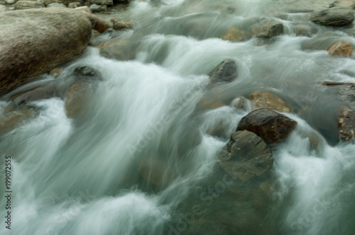 River water flowing through rocks at dawn photo