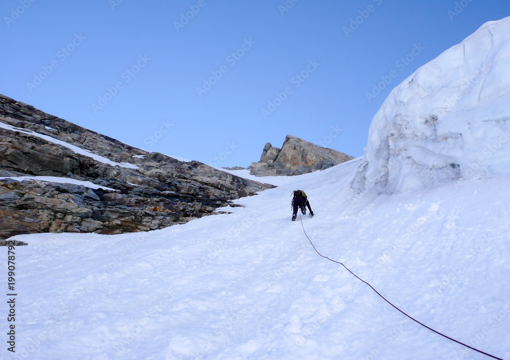 mountain climber heading up a steep hanging glaicer around seracs in the Alps of Switzerland