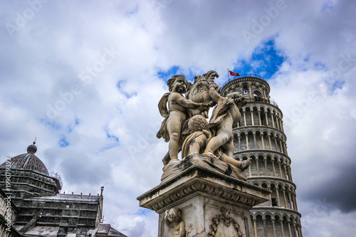 Fontana dei Putti and Leaning Tower of Pisa (Torre pendente di Pisa) in Piazza dei Miracoli (Square of Miracles) in Pisa, Tuscany, Italy. The Leaning Tower of Pisa is one of the main landmark of Italy