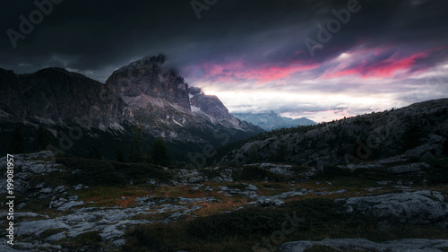 Red clouds of the sunrise with dramatic mountain landscape in the Dolomites Italy