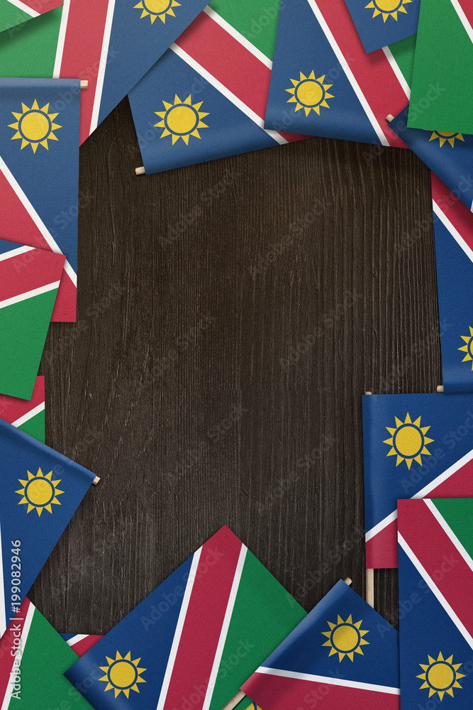 Namibia small flags framing a wood texture background with copy space Namibia small flags framing a wood texture background with copy space