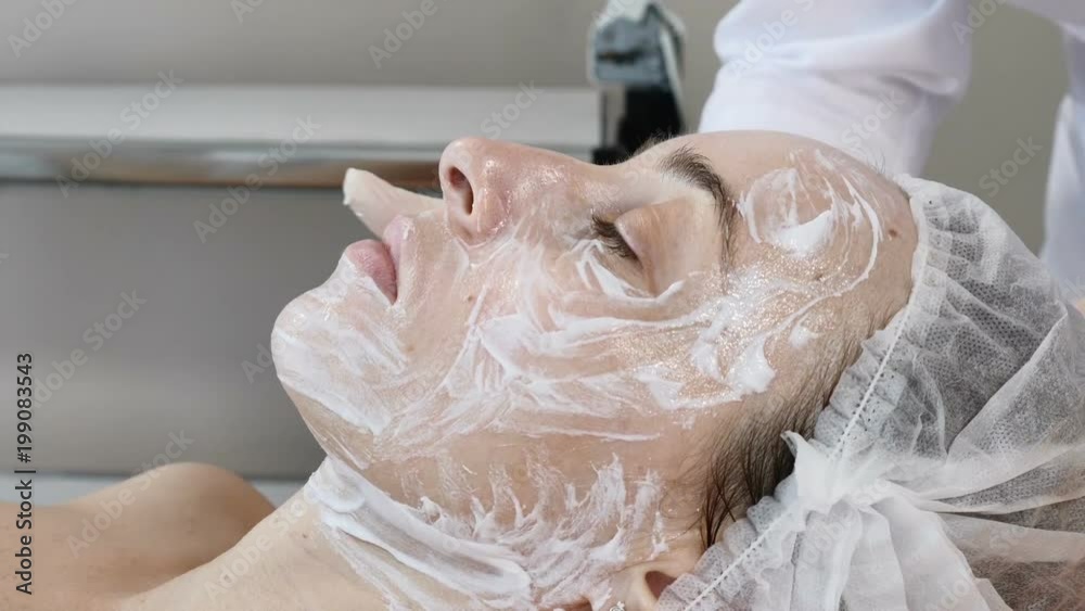 Cosmetician in gloves applying cosmetic cleaning mask before facial beauty procedure. Cosmetician in gloves applying cosmetic cleaning mask before facial beauty procedure.