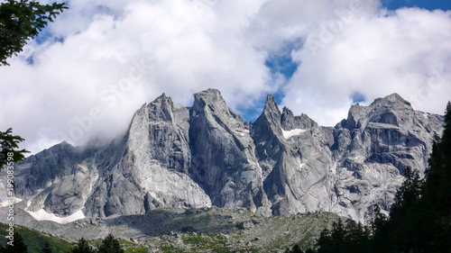 fantastic mountain landscape in the Swiss Alps with jagged sharp granite peaks under a cloudy sky