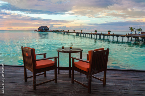 Restaurant on the water on the background of beautiful colorful sunset over the ocean