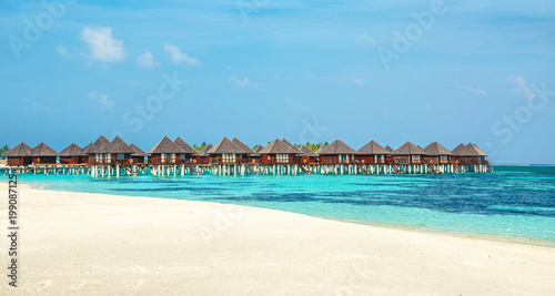 Wooden bungalow on the background of azure water and blue sky, Maldives