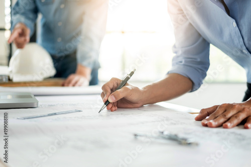 Close-up Of Person's engineer Hand Drawing Plan On Blue Print with architect equipment, Architects discussing at the table, team work and work flow construction concept photo