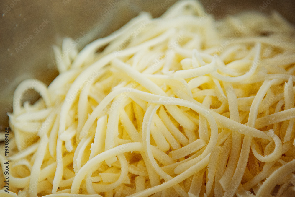 Grated cheese in a saucepan close-up.Food background. Grated cheese in a saucepan close-up.Food background.