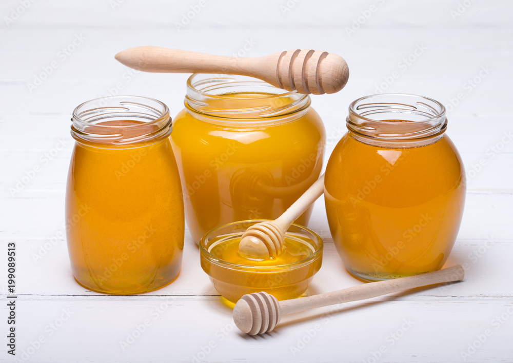 Honey with wooden honey dipper on wooden table Honey with wooden honey dipper on wooden table