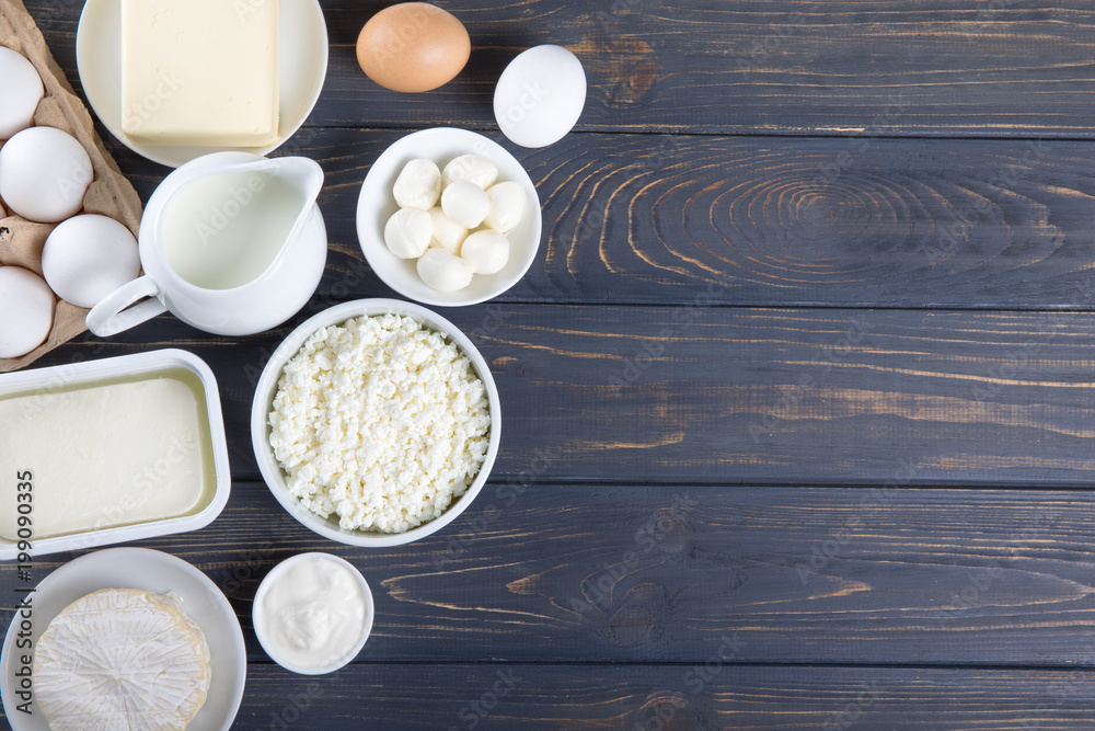 Dairy products on wooden table. Milk, cheese, egg, curd cheese and butter.
