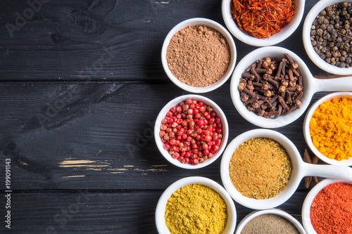 colorful spices in ceramic containers on a dark background