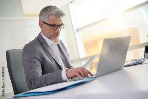 Businessman in office working on laptop