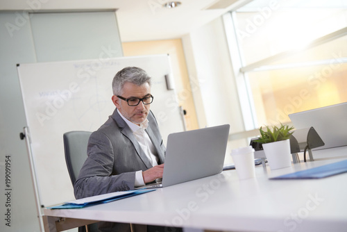 Businessman in office working on laptop