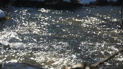 Melting ice on the river in the forest, white snow on the river banks photo