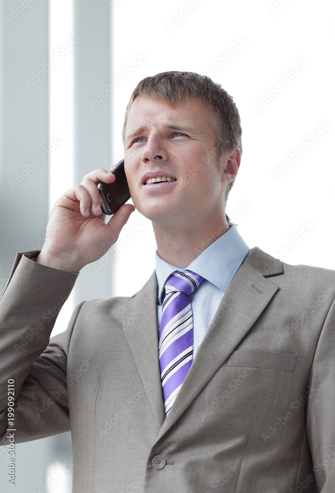 Businessman at the window talking on the phone Businessman at the window talking on the phone