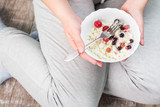 The girl is holding a plate of cottage cheese. Healthy eating concept. Cottage cheese with berries. Girl in home clothes. Proper nutrition. Diet. Plump girl. Health. Small depth of field.