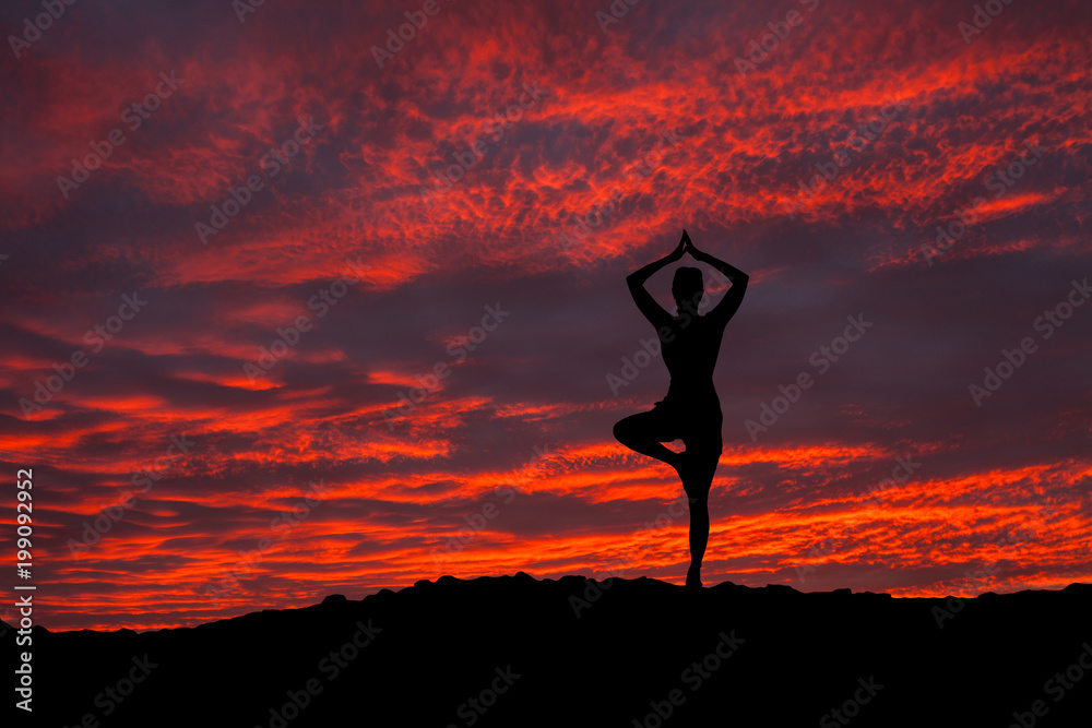 The woman with yoga posture on the mountain at sunset. The woman with yoga posture on the mountain at sunset.