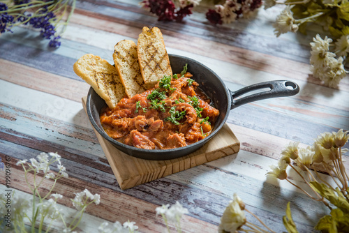 Sprat in tomato sauce, top view, rustic.