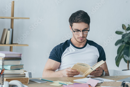 handsome male student reading book