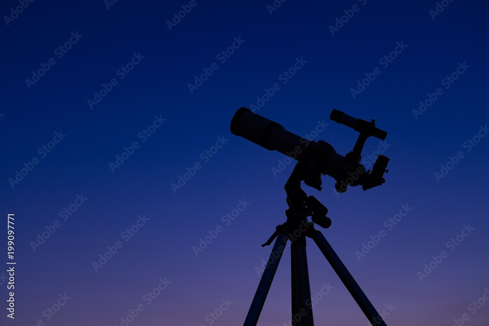 Silhouette of a telescope with evening sky in the background.