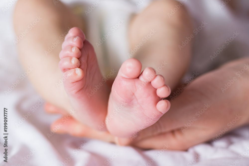 Beautiful image of the feet of a newborn baby in female hands Beautiful image of the feet of a newborn baby in female hands