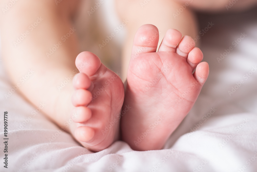 Baby legs on a white blanket. Narrow focus Baby legs on a white blanket. Narrow focus