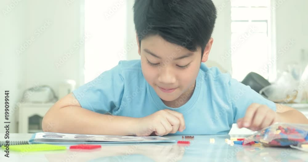 Cute asian boy playing plastic block at home with smile face. Cute asian boy playing plastic block at home with smile face.