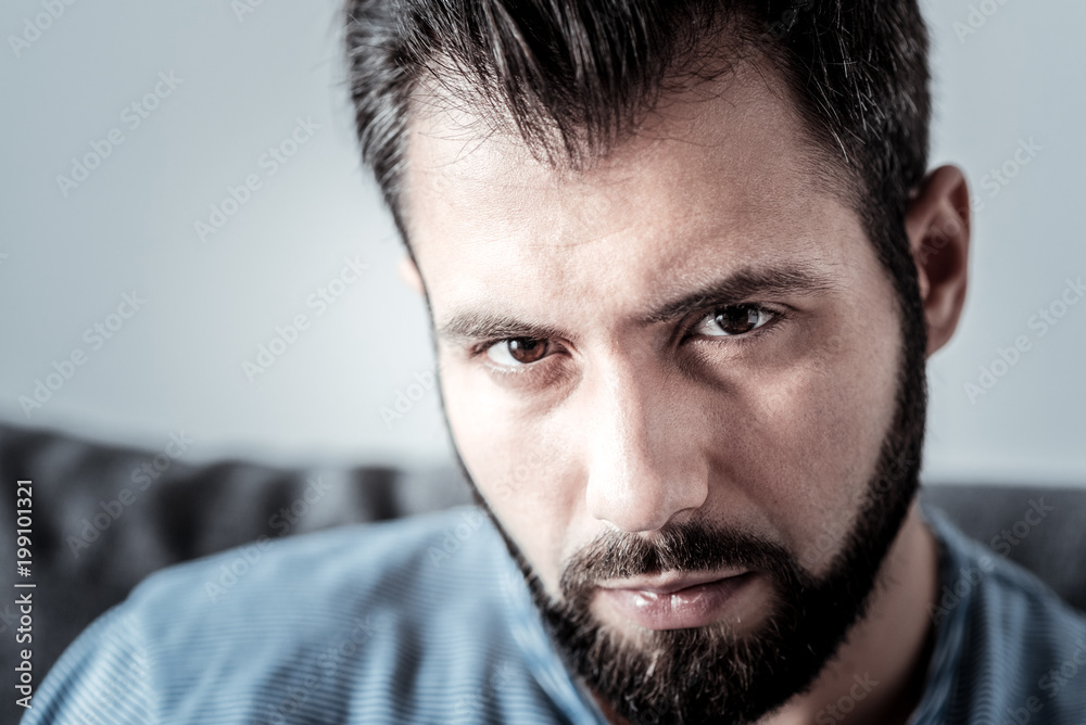 Facial expression. Portrait of a sad cheerless bearded man looking at you while thinking about his life problems Facial expression. Portrait of a sad cheerless bearded man looking at you while thinking about his life problems