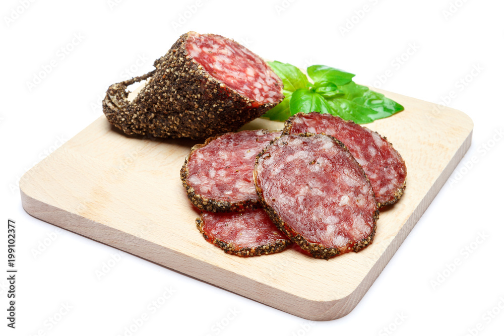 Dried organic salami sausage covered with pepper on wooden serving board Dried organic salami sausage covered with pepper on wooden serving board
