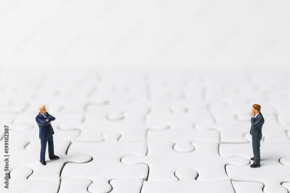 Miniature people: Businessman standing on white jigsaw. Business concept.
Miniature people: Businessman standing on white jigsaw. Business concept.
