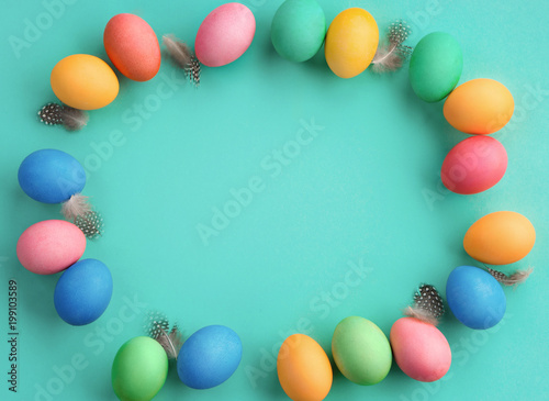 Happy Easter! Turquoise background with colorful easter eggs. Top view with copy space.