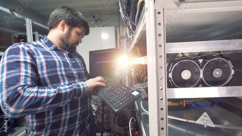 Male IT Technician Working in cryptocurrence mining factory. photo