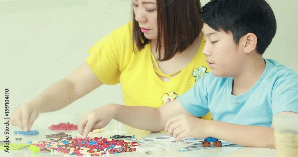 Happy asian family mother and son playing plastic block together . Happy asian family mother and son playing plastic block together .