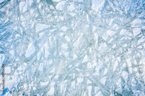 Textured background of white and blue ice with snow patterns.