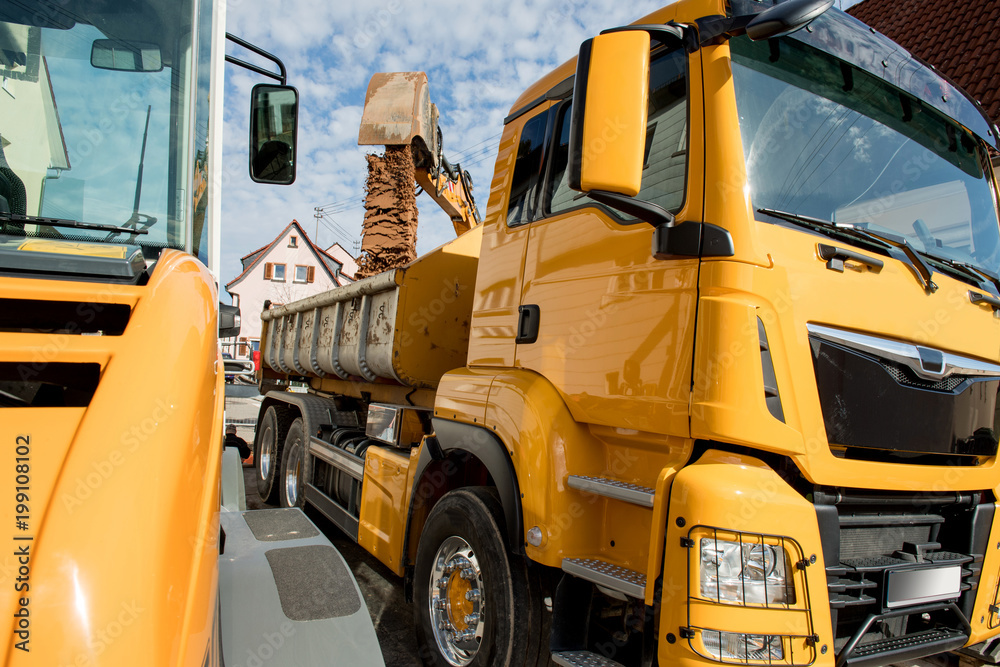 Bagger belädt Last Kraft Wagen mit Erdaushub