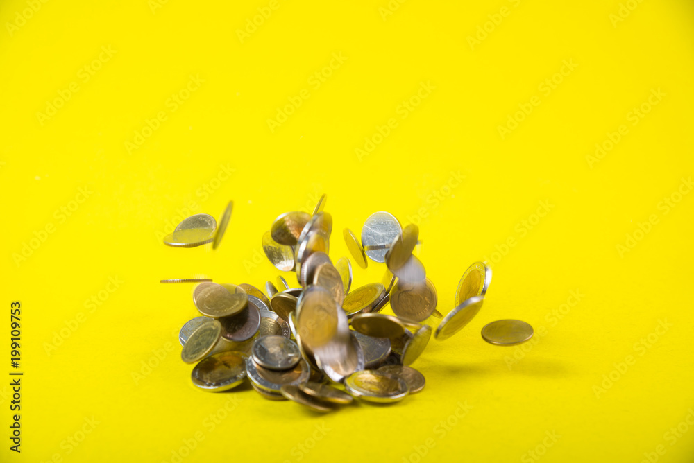 Falling coins money on yellow background, business wealth concept.