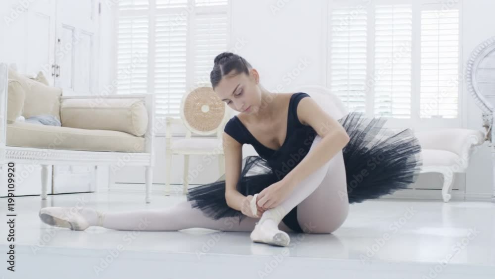 Graceful ballerina practicing ballet in white studio, slow motion Graceful ballerina practicing ballet in white studio, slow motion