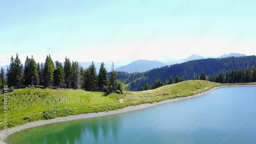aerial view of Tirol Austria Alpine forest and trees next to a lake in the mountains on a summer day with blue sky. drone footage. an amazingly beautiful landscape aerial view of Tirol Austria Alpine forest and trees next to a lake in the mountains on a summer day with blue sky. drone footage. an amazingly beautiful landscape