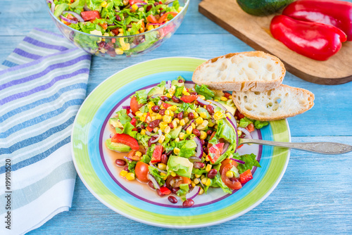Traditional Vegetarian American Southwest Salad with vegetables, avocado, beans and corn on a rustic background