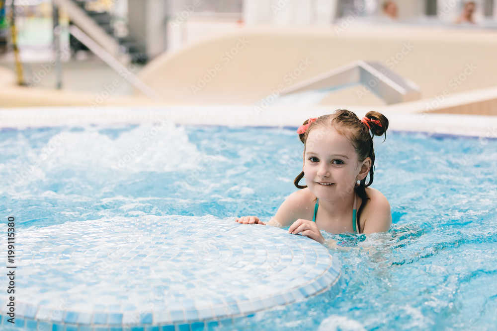 Little happy girl playing in a jacuzzi. Little happy girl playing in a jacuzzi.
