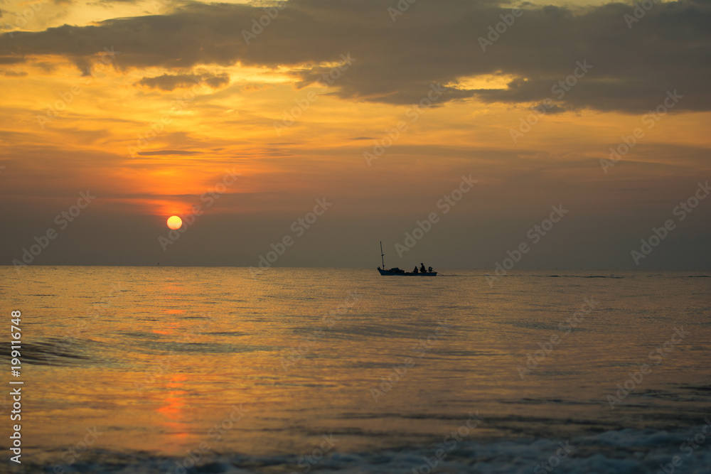 silhouette of fishing boat on sunset sea