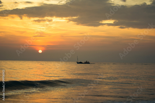 silhouette of fishing boat on sunset sea